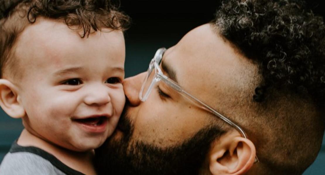 man kissing baby's cheek